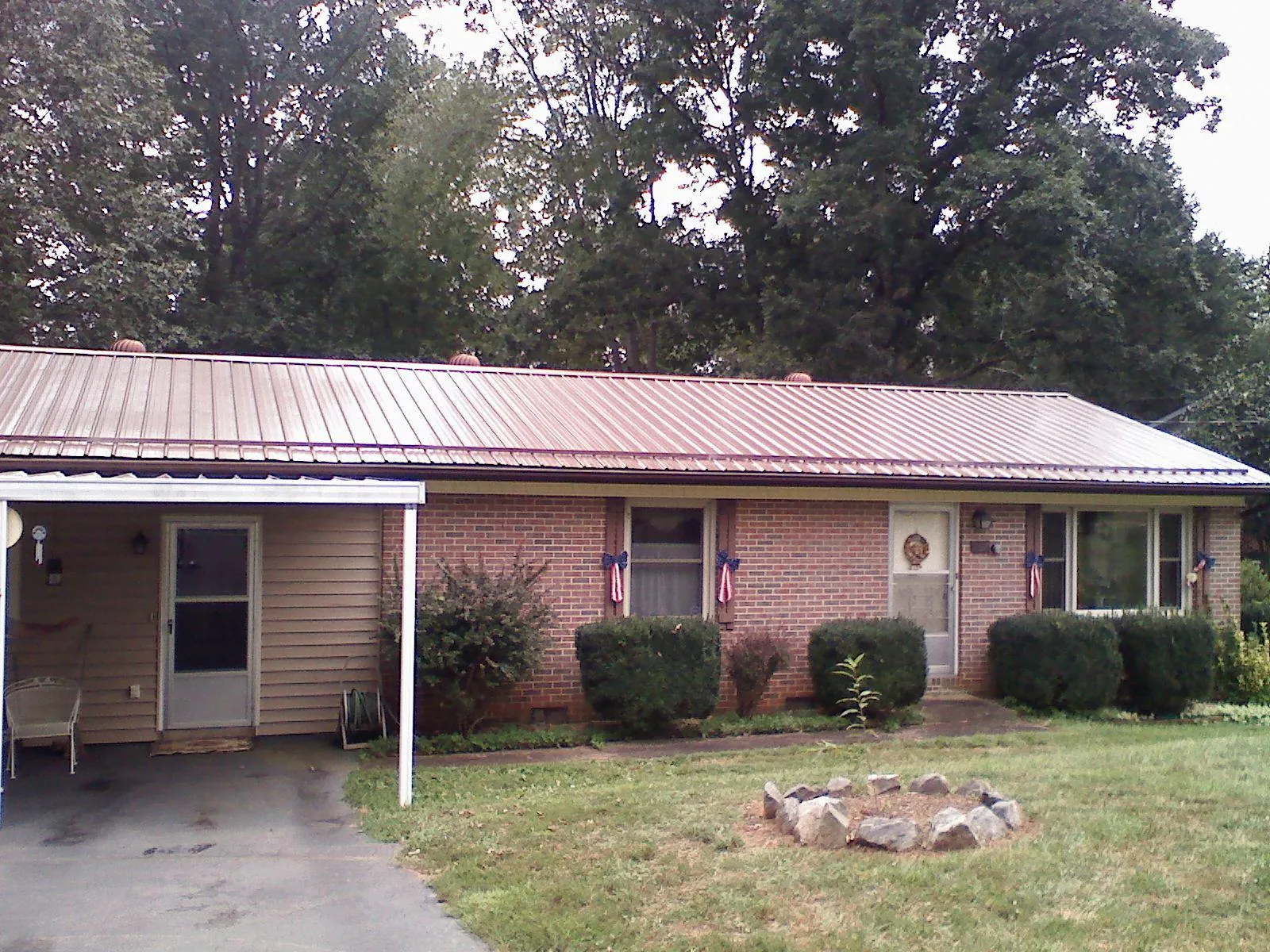 Bronze metal roof and carport on a brick ranch home — Roof Repair work by our crew in Opa Locka